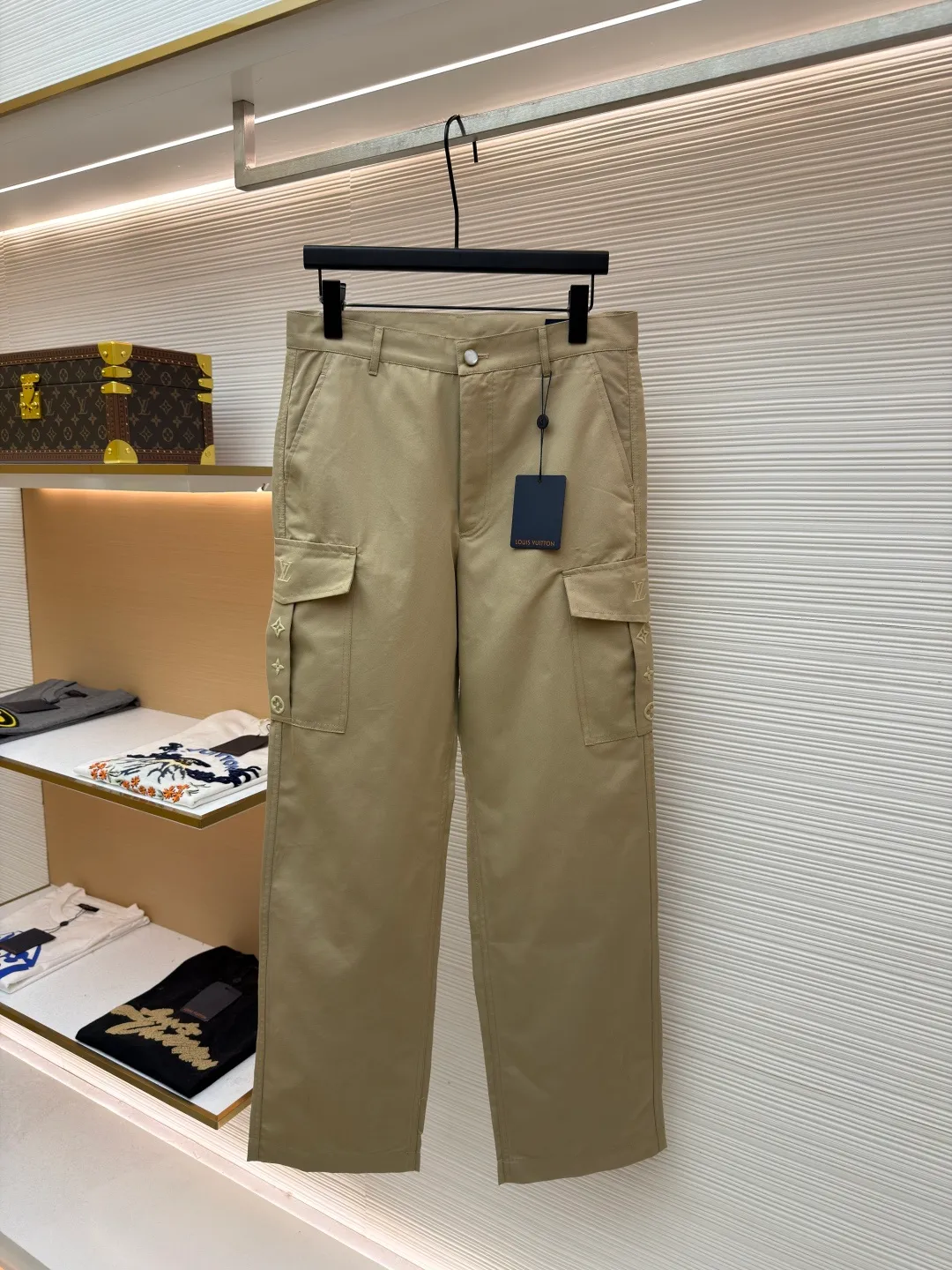 LOUIS VUITTON pocket embroidered work trousers ●Original version: Purchased and developed by 11318 ●Item number: 1681826-B50 ●Fabric: cotton twill fabric ●Technology: embroidery production ●Color: Khaki ●Version: Fitted version ●Weight: about 505 grams ●Size: 44-46-48-50 ●Description: The high cotton content ensures the fabric's excellent breathability, durability and classic workwear texture, while the twill weave gives it unique wear resistance and stiffness. The special fabric technology solves the pain points of tight and stiff traditional overalls; it provides greater freedom when moving, significantly improves wearing comfort and flexibility, and achieves a balance between function and comfort. The application of three-dimensional core-spinning embroidery technology in the pocket position is achieved by adding additional cotton thread or foam as the core material to the pattern filling layer, and then using embroidery thread to fully cover the embroidery. The logo pattern is significantly protruded from the surface of the fabric, forming a full three-dimensional effect. This process not only enhances the visual impact and tactile level, but also improves the wear resistance of the pocket area through the buffering effect of the core material, ensuring that the pattern can still remain crisp and not deformed in complex daily use, ensuring that the pattern is clear and durable, and injecting a sense of sophistication into the rugged workwear style. Diversified pocket system combines workwear functionality with sophistication. The flap cargo pockets on both sides are a signature element, and their flap design prevents items from falling and enhances the visual three-dimensionality. Italian style pockets provide simple side storage. The overall wiring is straight and delicate, the fabric is comfortable and soft, and the color is consistent without color difference. It can be matched with the same style to create a fashionable look and control various occasions. Customized accessories, complete with three standards, same style for men and women!